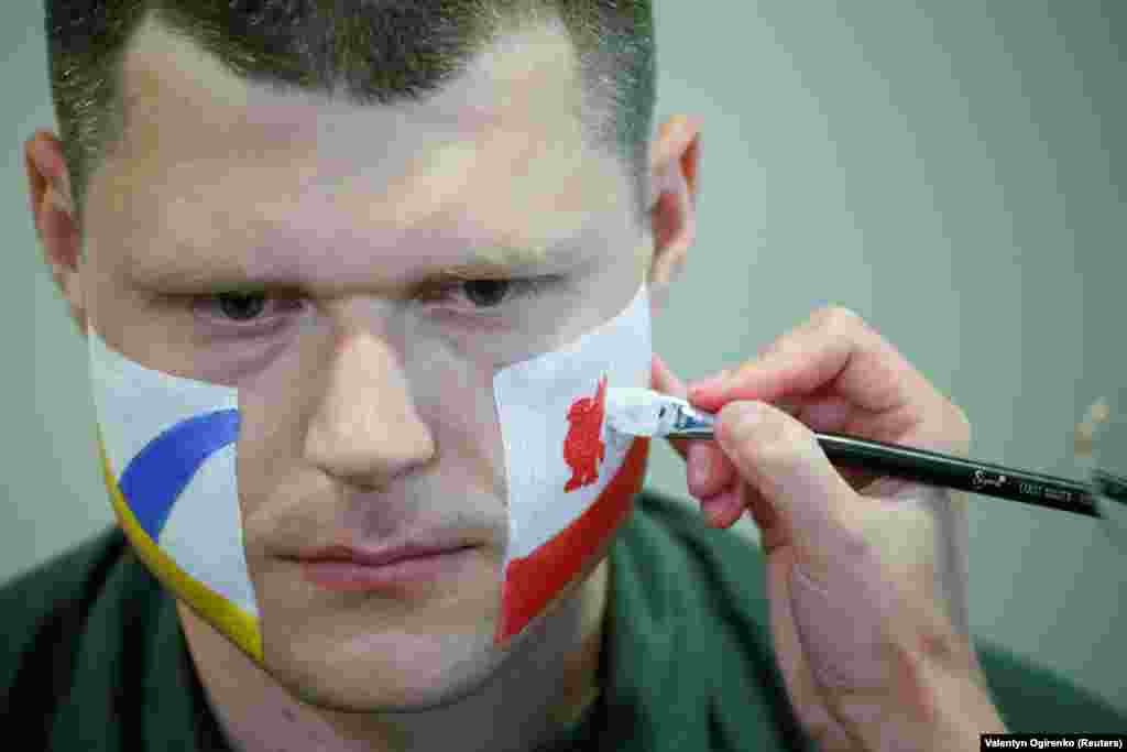 An officer with the Ukrainian State Border Guard Service has his face painted in the colors of both Champions League finalists, Liverpool and Real Madrid, as he prepares to meet soccer fans at the Boryspil International Airport outside Kyiv on May 25.