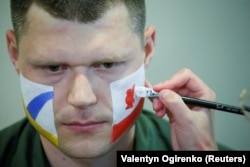 An officer with the Ukrainian State Border Guard Service has his face painted in the colors of both Liverpool and Real Madrid as he prepares to meet soccer fans at the Boryspil International Airport outside Kyiv on May 25.