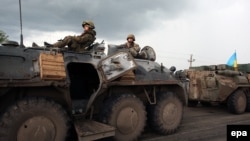 Ukraine - Unmarked soldiers wait on the road as separatists block the Kramatorsk road to prevent them from advancing near Krematorsk, Ukraine, 02 May 2014. 