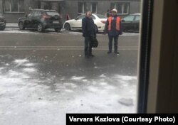Рабочыя чысьцяць ад сьнегу дах дому на вуліцы Ленінградзкай у Менску. Фота Варвары Казловай, 10 студзеня