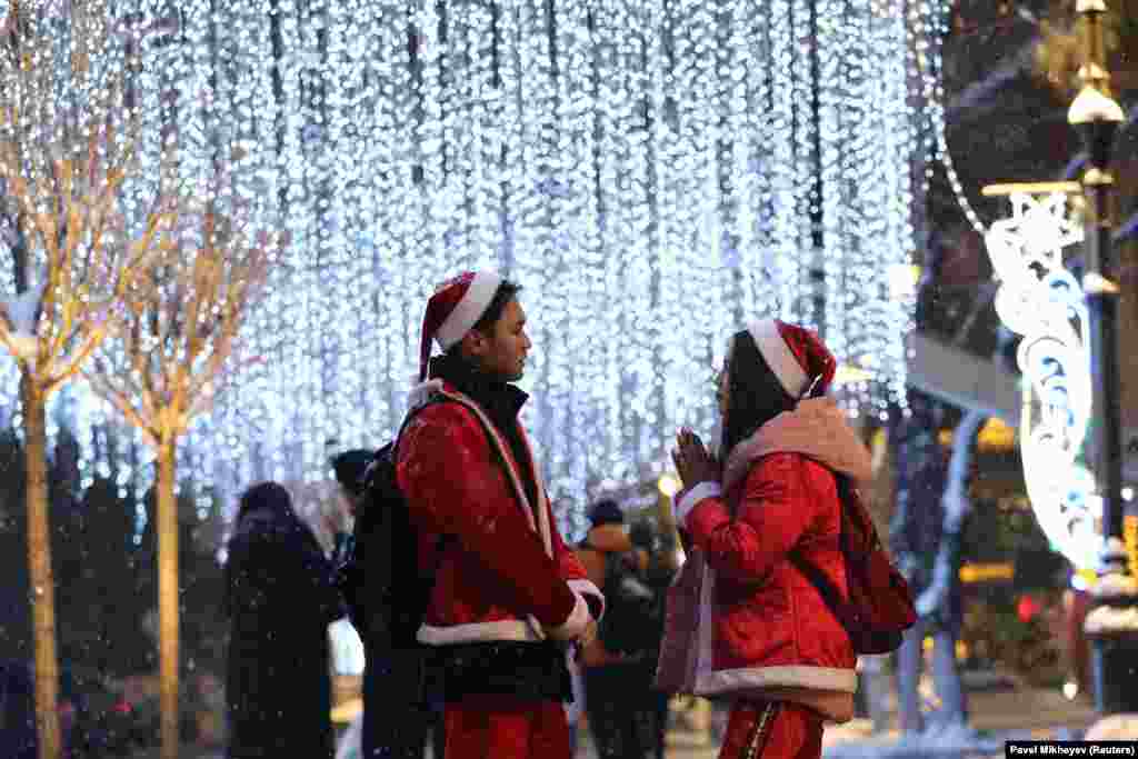 People dressed as Santa Claus stand next to Christmas lights in Almaty, Kazakhstan. (Reuters/Pavel Mikheyev )
