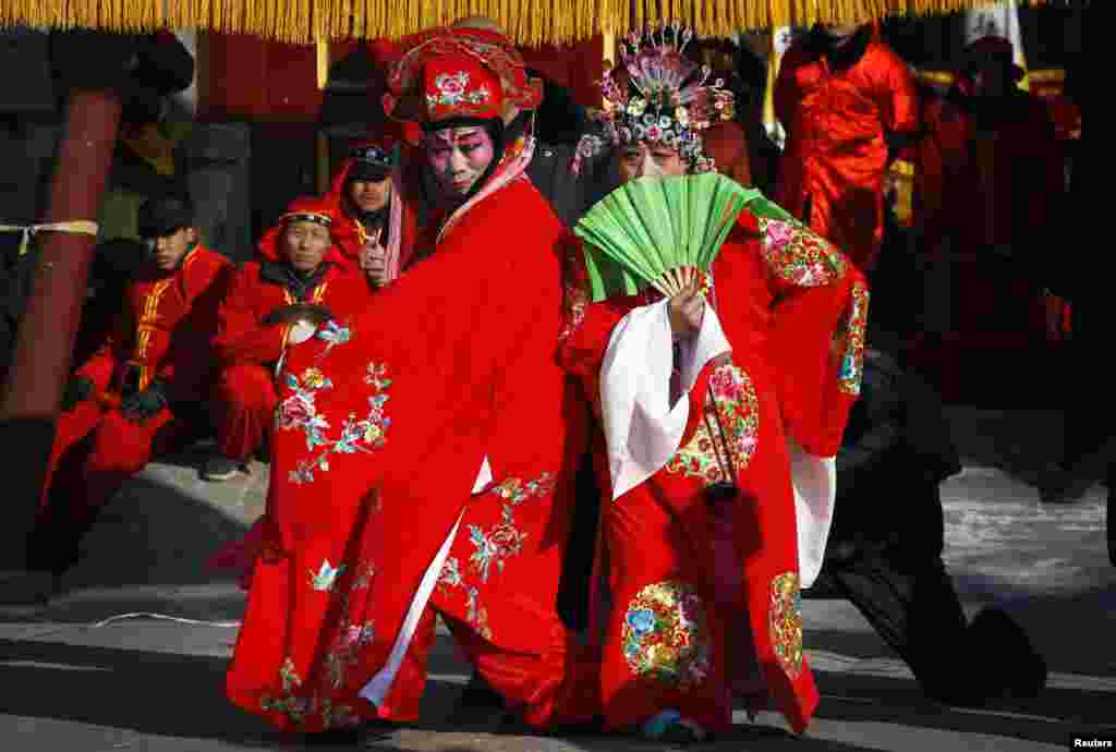 Performers dressed in traditional costumes and wearing make-up dance as they take part in Chinese New Year celebrations at the 700-year-old Dongyue Temple in Beijing.