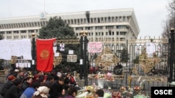 People pray for those killed in the violence outside the gates of the government building in Bishkek last April. 