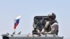 SYRIA -- A Russian soldier guards a checkpoint as displaced Syrians from the Daraa province come back to their hometown in Bosra, southwestern Syria, July 11, 2018