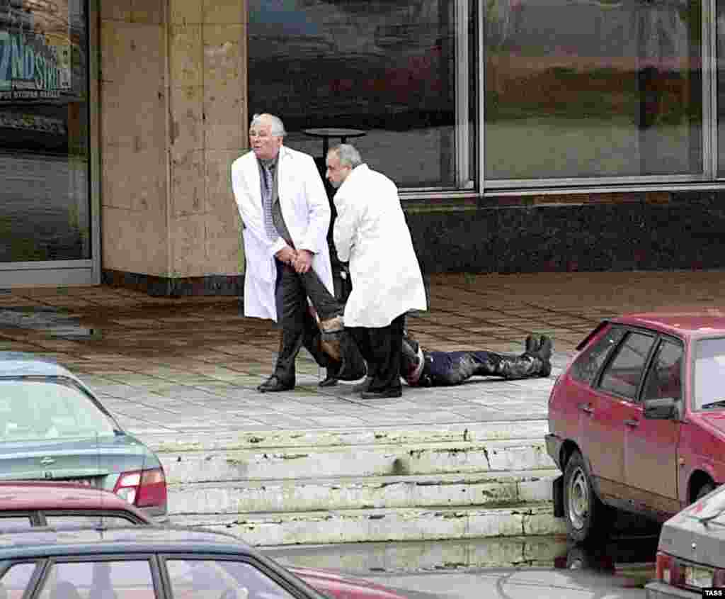 Врачи выносят тело одного из заложников, убитого боевиками. 