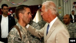 Then-U.S. Vice President Joe Biden talks with his son, U.S. Army Captain Beau Biden, at Camp Victory on the outskirts of Baghdad in July 2009.