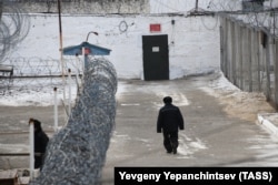 A prisoner walks past fencing at the maximum security correctional colony in the village of Shara-Gorokhon, Karymsky district.