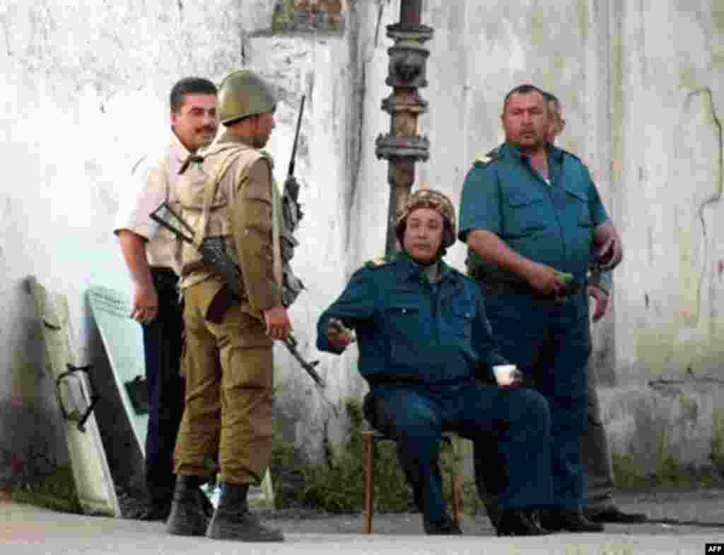 Local police talk to a soldier as they guard a street in Andijon three days after the most intense violence - Tashkent has rejected appeals for an international inquiry to establish what happened, saying it's an internal Uzbek affair.