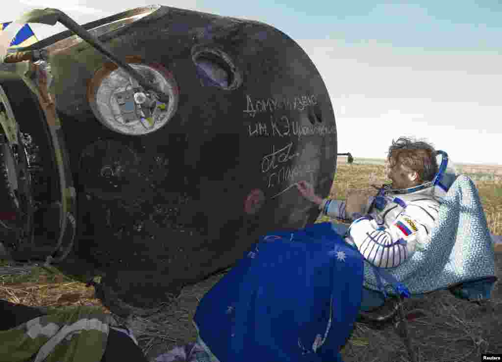 Padalka, who piloted the spacecraft back to Earth, was the first to be pulled out of the charred Soyuz capsule. Here, he signs his name on the side of the capsule, which will be displayed at the Tsiolkovsky Museum in the town of Kaluga, southwest of Moscow.