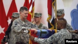 U.S. military personnel fold their unit flag during a ceremony marking the withdrawal of 1,000 U.S. soldiers from a military base at the Basra airport on September 7.