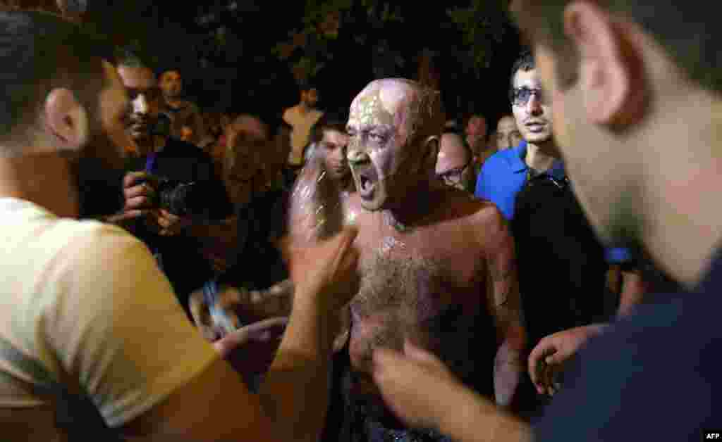 Protesters help a man after he attempted to self-immolate in front of a police station that had been seized by gunmen in the Armenian capital, Yerevan. (AFP/Karen Minasian)