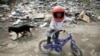 A boy rides a bike in a Romany settlement in Sarajevo&#39;s suburb of Butmir, Bosnia-Herzegovina.