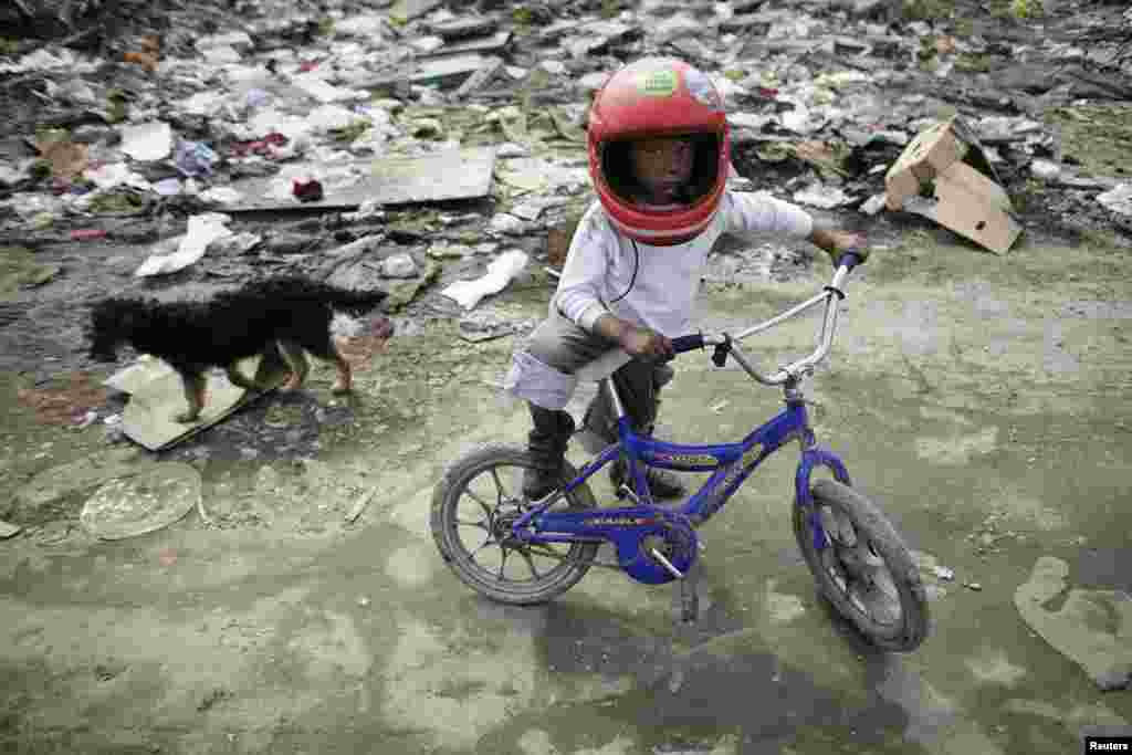 A boy rides a bike in a Romany settlement in Sarajevo's suburb of Butmir, Bosnia-Herzegovina.