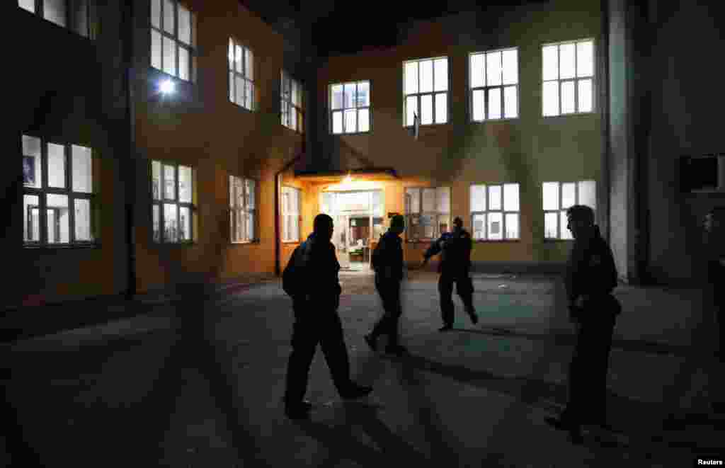 Косовската полиција пред изборно место во училиштето „Свети Сава“ во Митровица. 