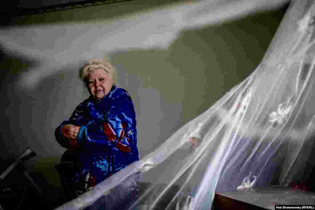 Vera shows her damaged house.