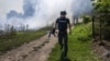 На передньому плані журналіст AFP, а позаду піднімається дим після обстрілу. Донеччина, 31 липня 2022 року