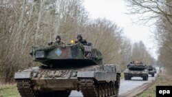 Солдаты на танках Leopard 2 продвигаются на военном полигоне Биедруско в Бедруско, 24 марта 2014 г.