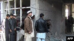 Afghans inspect the site of a bomb blast in Khost Province on January 6.