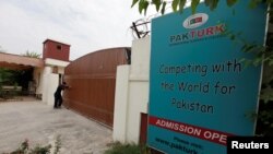 Пәкістан астанасы Исламабадтағы PakTurk оқу орны қақпасын жауып жатқан адам. 2 тамыз 2016 жыл.