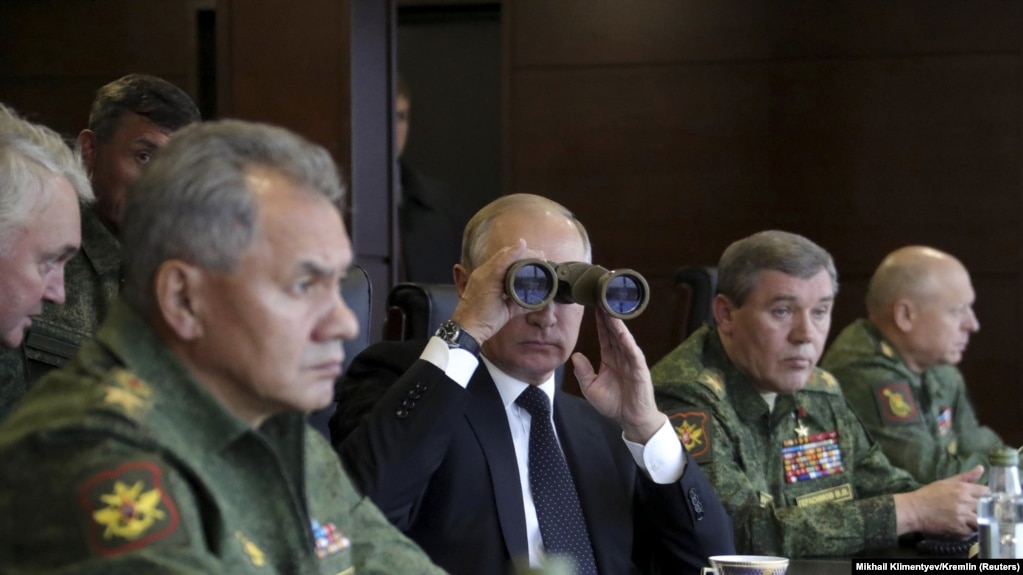Russian President Vladimir Putin uses binoculars to watch the Zapad 2017 war games, held by Russian and Belarusian forces, with Defense Minister Sergei Shoigu (left).