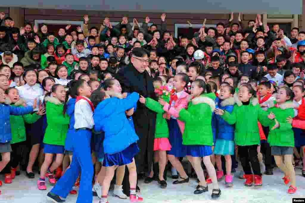 North Korean leader Kim Jong Un is hugged by children during a visit to Samjiyon County in this undated photo released by the Korean Central News Agency. (Reuters/KCNA)