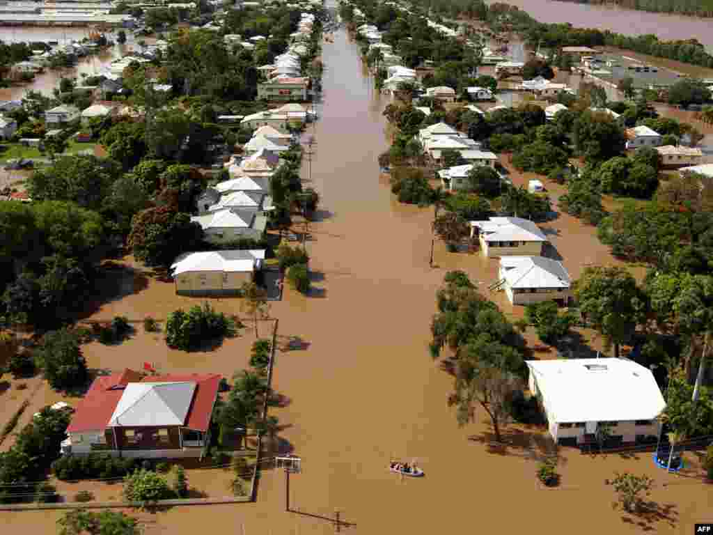 AUSTRALIA, Rockhampton : Rising floodwaters spread through the low-lying suburb of Depot Hill in Rockhampton, in eastern Queensland. The Australian military and emergency services were battling huge flooding in the country's northeast that has left at least one person dead, amid warnings the worst of the devastation is to come. NO SALES RESTRICTED TO EDITORIAL USE AUSTRALIA OUT AFP PHOTO / MECHIELSEN LYNDON 