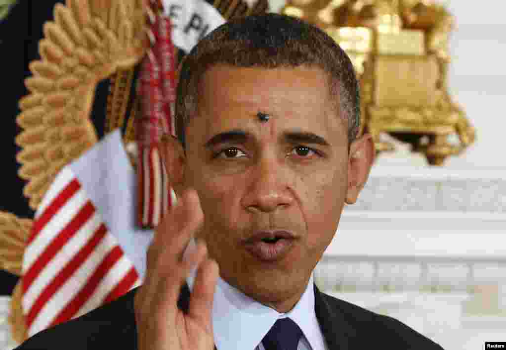 A fly lands between the eyes of President Barack Obama while he speaks in the State Dining Room of the White House. (Reuters/Larry Downing)