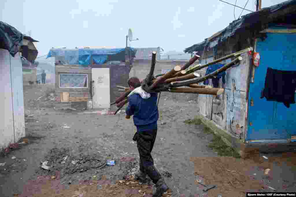 A man returns from collecting wood to heat his home.