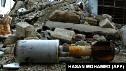 A used rocket lies amid the rubble in Douma.