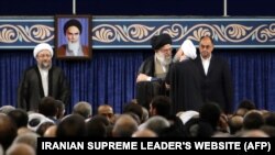 A handout picture released by the official website of the Iranian supreme leader Ayatollah Ali Khamenei shows him (2L) embracing President Hassan Rouhani, August 3, 2017