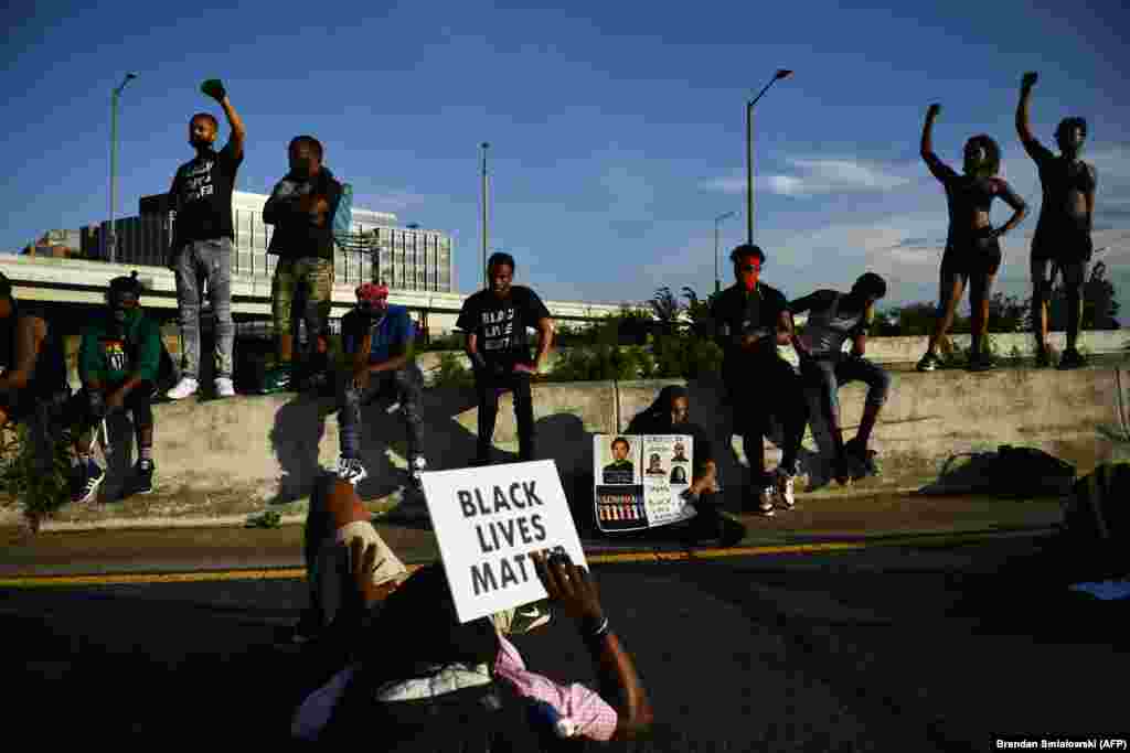 Demonstrators chant as others lay on a highway blocking traffic, as protests triggered by the death of George Floyd while in police custody, continue on June 23, 2020, in Washington, DC.