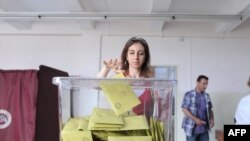 Voters cast their ballots at a polling station in Istanbul in national parliamentary elections on June 12.