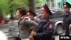 Қарсылық акциясы кезінде полицияның журналист Жанна Байтелованы ұстап, әкетіп бара жатқан сәті. Алматы. 1 мамыр 2010 жыл.