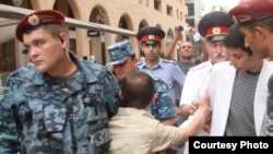 Tigran Arakelian is corraled by police in an undated photo from a protest in Yerevan