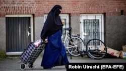 Женщина, одетая в никаб, на улице Роттердама