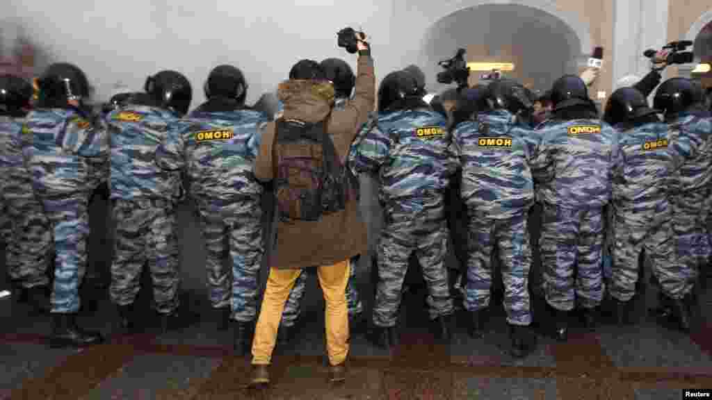 OCTOBER 31, 2012 -- A photographer takes pictures of Interior Ministry officers during a protest rally to defend Article 31 of the Russian Constitution, which guarantees the right of assembly, in St. Petersburg. (Reuters/Alexander Demianchuk)