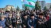 Local people hold Ingushetian flags as they attend a rally to protest against a controversial border deal with neighboring Chechnya in Magas on March 26, 2019.