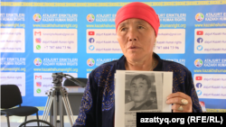 Nauatkhan Jakyp with a picture of her son,  Zheniskhan, whom she hasn't seen in more than two years. 