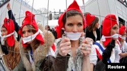 Manifestante în costume simbolizând Revoluția Franceză după un gard de sârmă, în timpul unui protest la Paris.