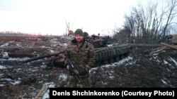Денис Шинкоренко стоїть біля танка на сході України