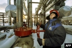 Ресейдің Ямало-Ненецк округіндегі газ құбыры шүмегін бұрап жатқан "Новатэк" компаниясының жұмысшысы. (Көрнекі сурет)