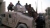 Sunni gunmen sit on top of an Iraqi Army vehicle left by Iraqi soldiers during clashes in the city of Fallujah on January 9.