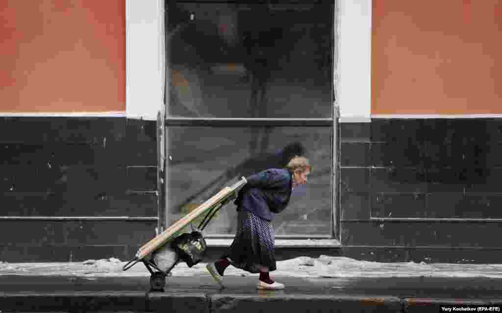 An elderly woman walks on a street in Moscow. (epa-EFE/Yuri Kochetkov)​