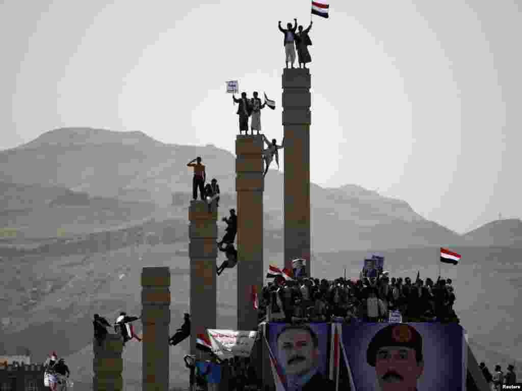 Supporters of Yemen's President Ali Abdullah Saleh stand on pillars during a rally to show their support in Sanaa on April 1. Embattled Saleh told a huge rally of supporters that he would sacrifice everything for his country, suggesting he has no plans to step down yet. Photo by Khaled Abdullah for Reuters