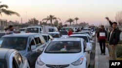 Iraqis drive their vehicles early on December 29 through the city of Ramadi, the capital of Iraq's Anbar Province, after Iraqi forces recaptured the city from Islamic State.