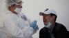 Kazakhstan - A health worker takes a swab from a man at a mobile testing station for the coronavirus disease (COVID-19) in Almaty, Kazakhstan June 17, 2020. REUTERS/Pavel Mikheyev