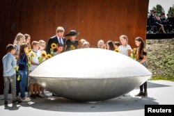 Regele Willem-Alexander și regina Maxima Olandei, împreună cu copii ce au inaugurat memorialul de la Vijfhuizen