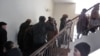 Пострадавшие от квартирных мошенниц поднимаются по лестнице в здании филиала партии «Нур Отан». Актобе, 17 января 2011 года.