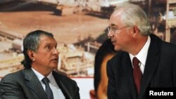 Venezuelan Energy Minister Rafael Ramirez (right) speaks with Rosneft President Igor Sechin in Caracas on January 29.