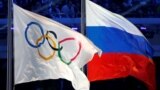 RUSSIA -- The Russian national flag (R) and the Olympic flag are seen during the closing ceremony for the 2014 Sochi Winter Olympics, Russia, February 23, 2014.
